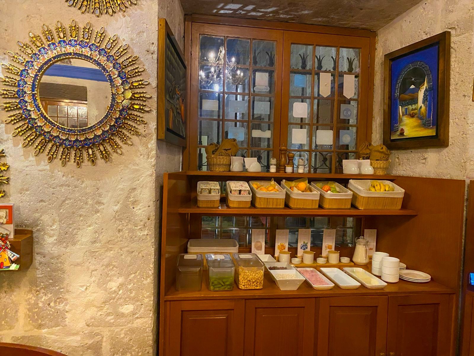 Exhibidor decorativo con estantes de madera, jabones y productos de baño junto a espejos de pared ornamentados.