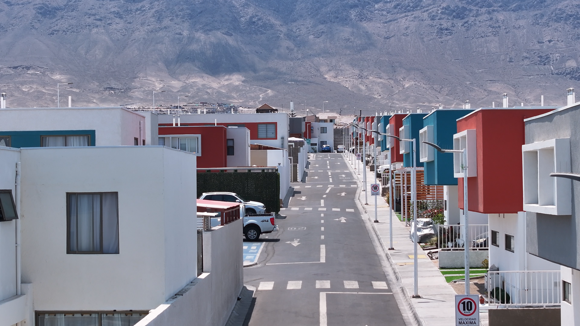 Una calle en una zona residencial con una señal de no estacionar