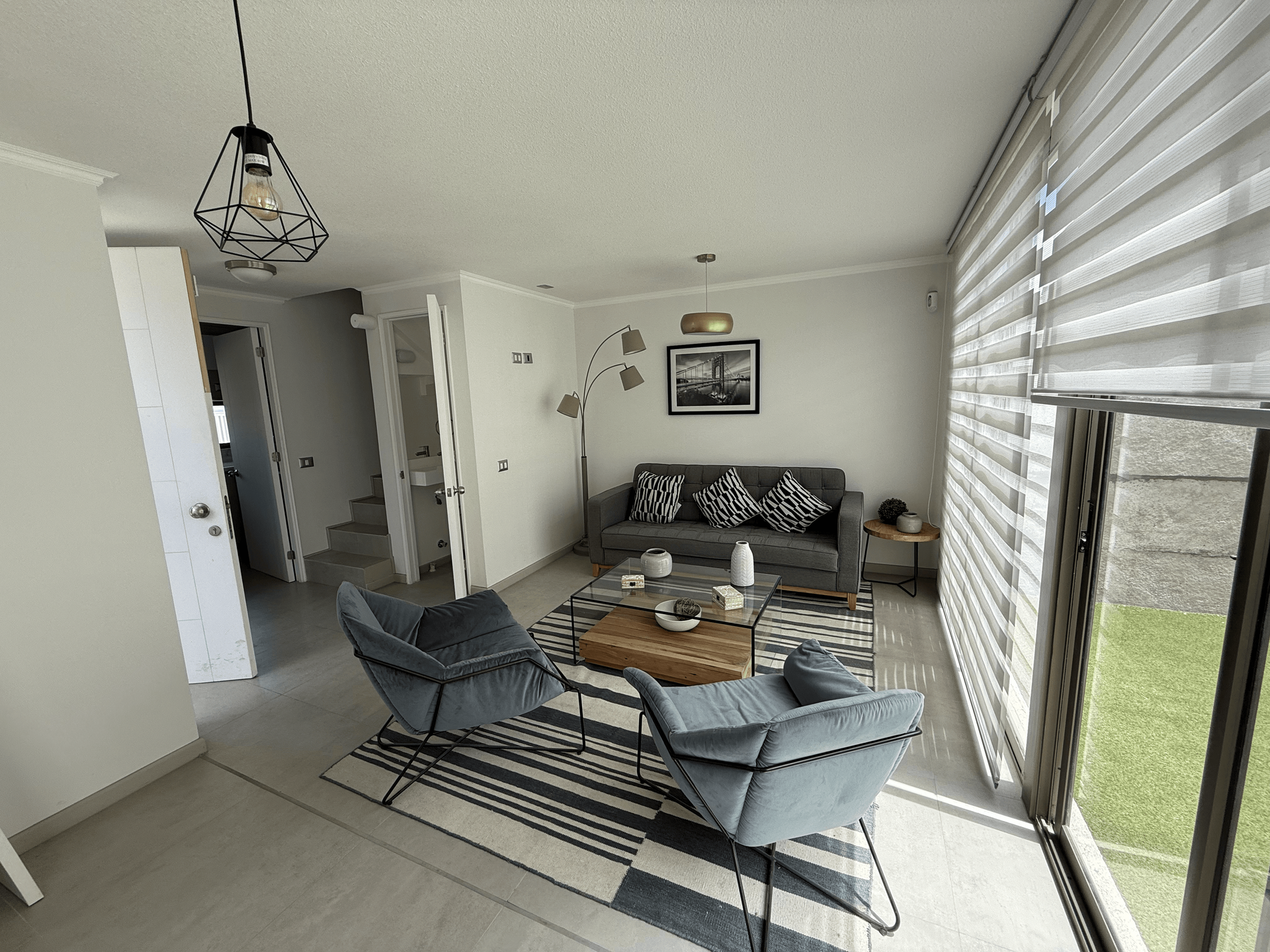 Una sala de estar con un sofá, sillas y una mesa de café.