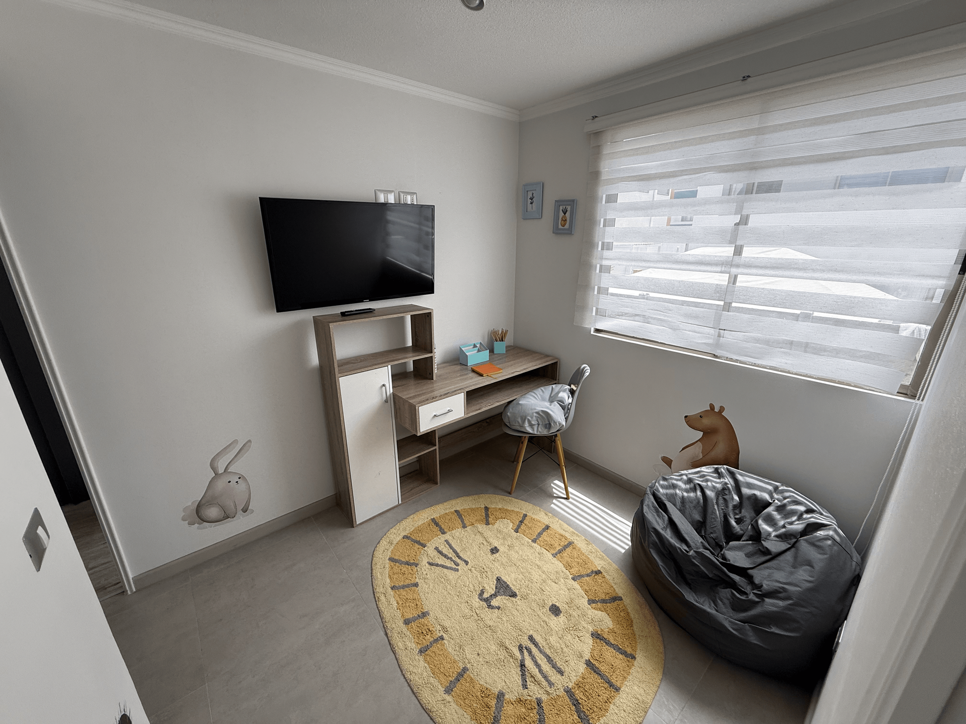 Una habitación con un reloj en el suelo y un televisor en la pared.