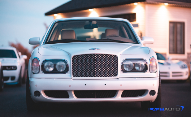 White Bentley Arnage parked, facing forward, with other cars in the background.