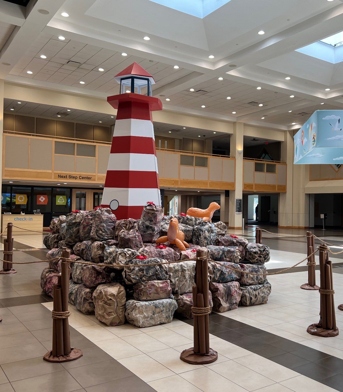 A large red and white striped lighthouse in a building