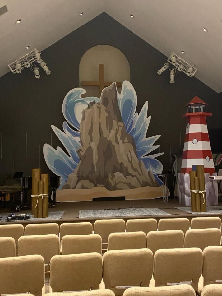 An auditorium with a lighthouse and a mountain on the wall