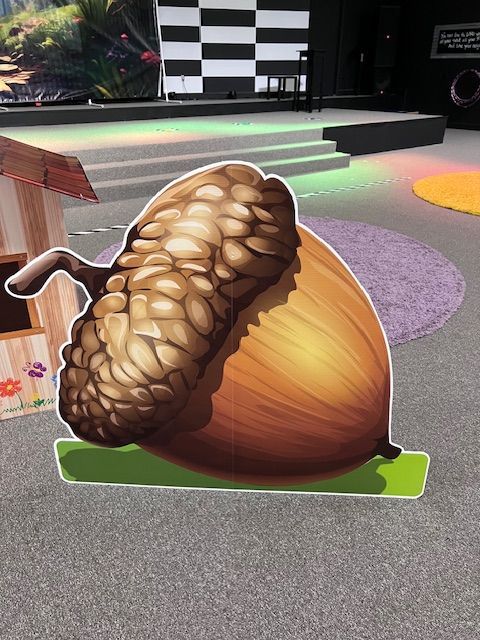 A cardboard cutout of an acorn sitting on the ground
