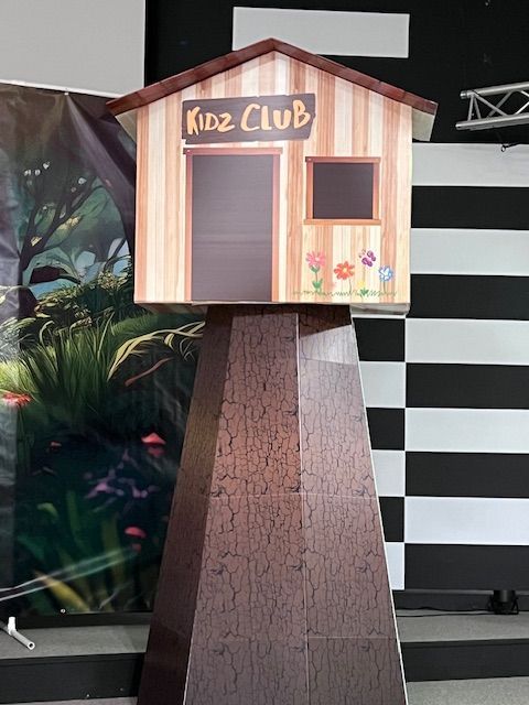 A wooden house with the words kidz club on it