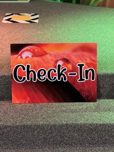 A check-in sign with a picture of a flower on it