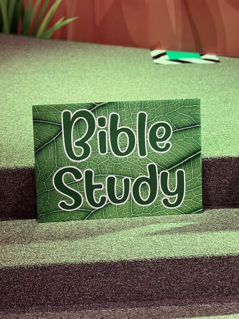 A green sign that says bible study on it