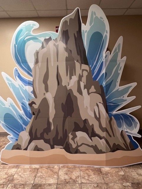 A cardboard cutout of a mountain with waves coming out of it