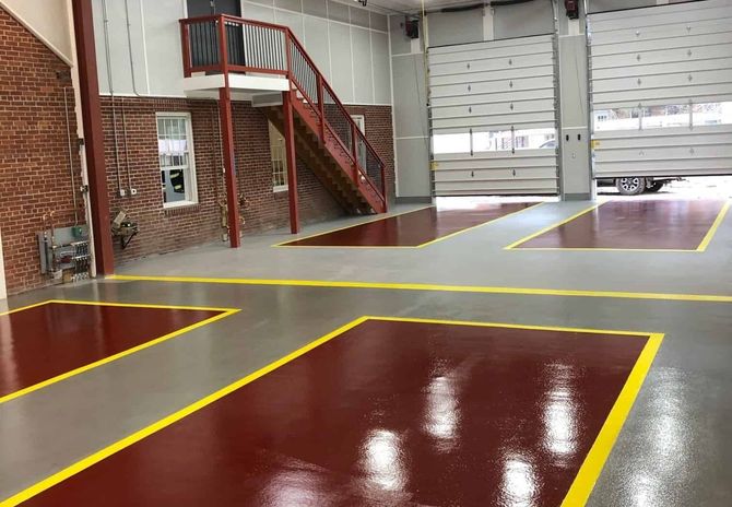 A large garage with a red floor and yellow lines.