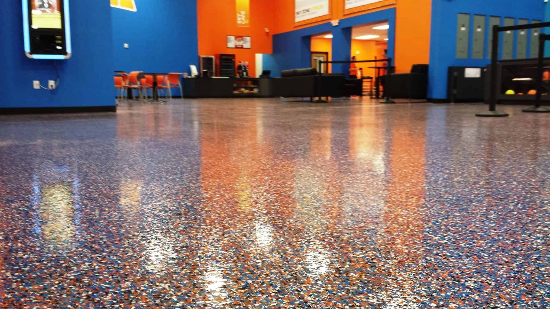 A large room with a shiny floor and blue and orange walls