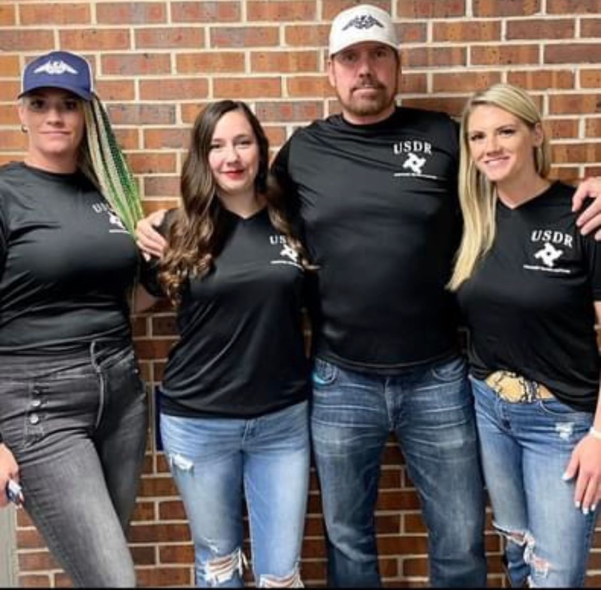 A group of people wearing usdr shirts are posing for a picture