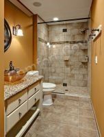 Bathroom with orange walls, white vanity, granite countertop, toilet, and tiled shower.