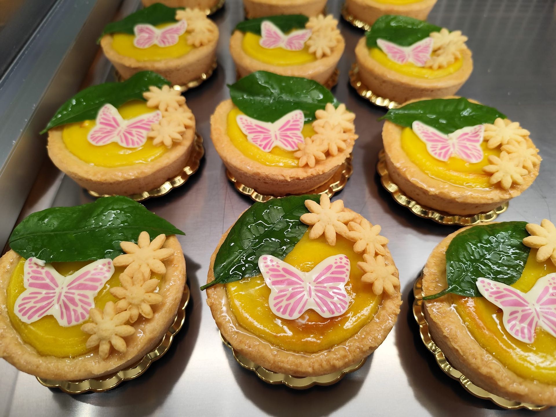 Un mucchio di cupcakes con farfalle e fiori sopra