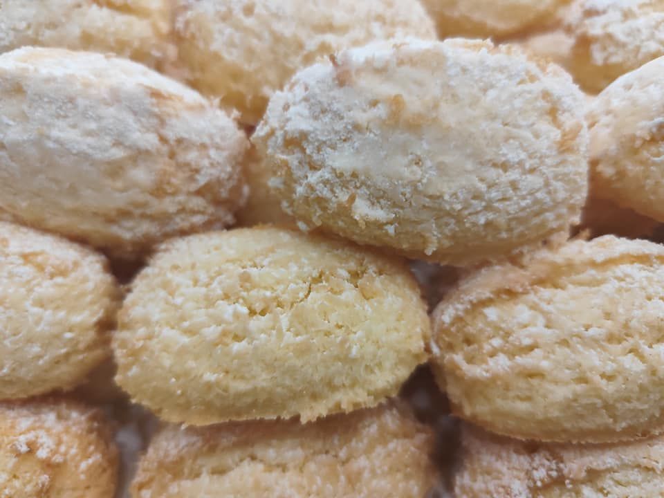 Un primo piano di una pila di biscotti ricoperti di zucchero a velo.