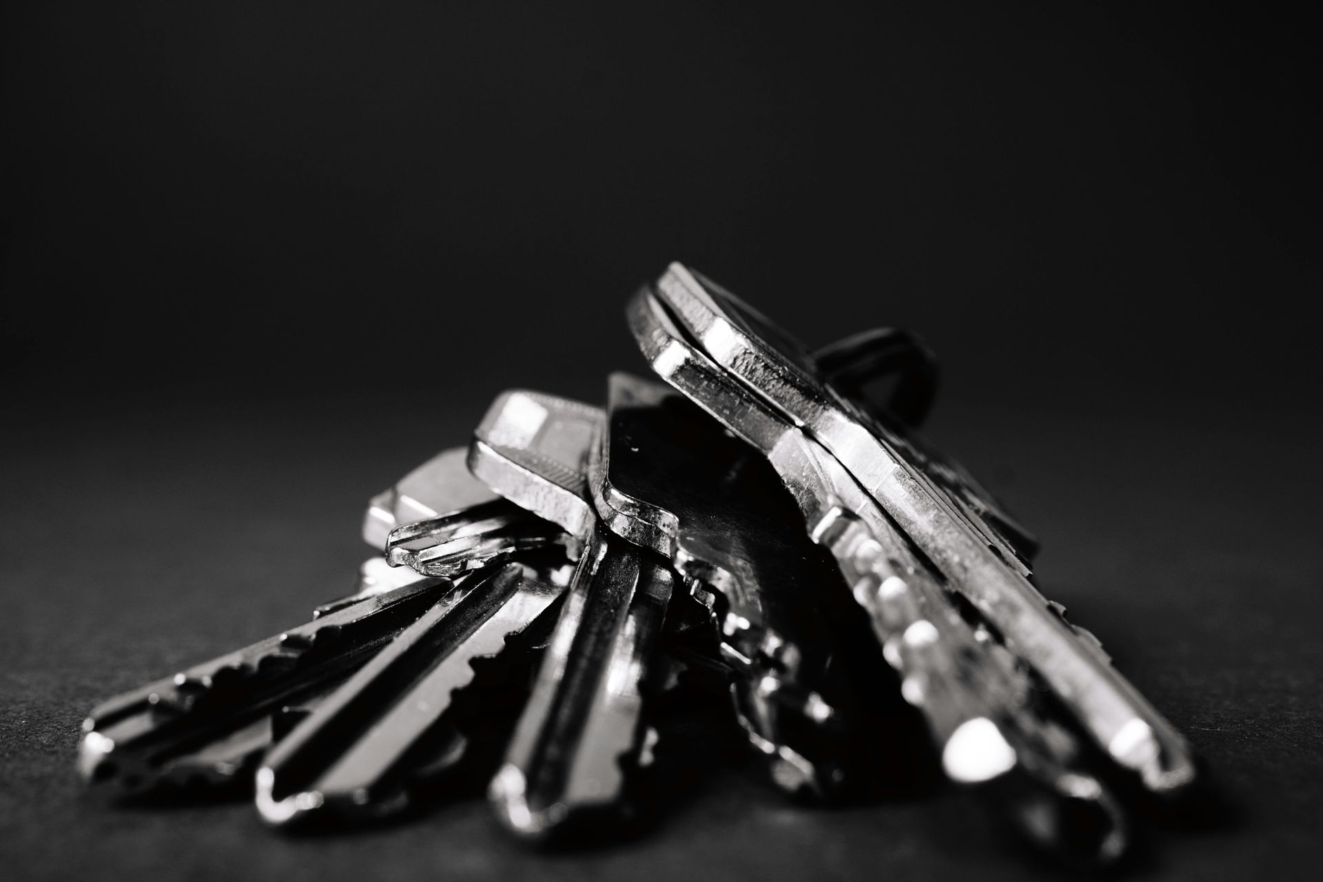 Bunch of shiny keys on a dark surface.