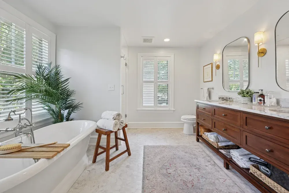 A bathroom with a bathtub , sinks , and two mirrors.