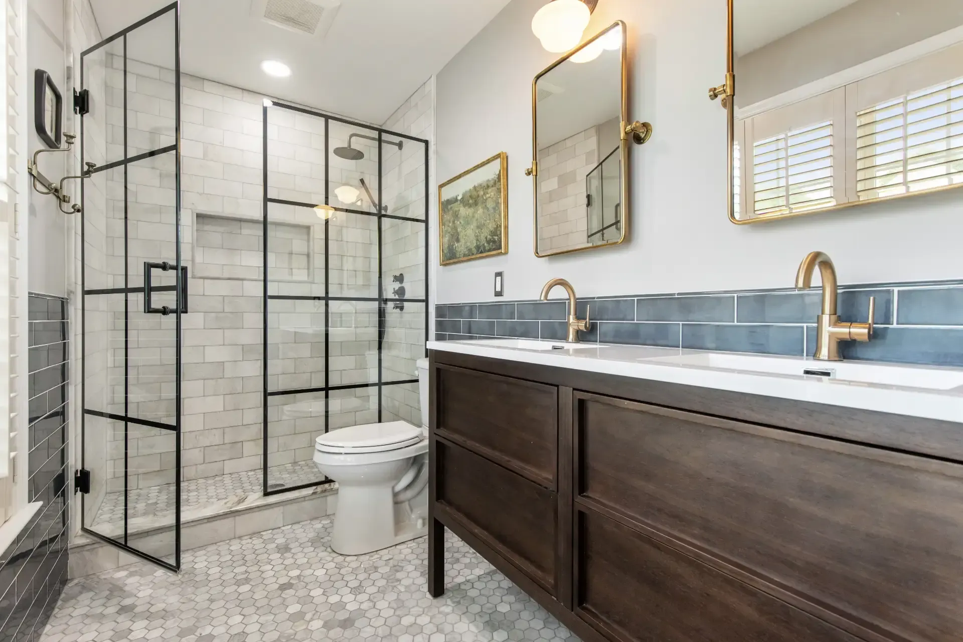 A bathroom with two sinks , a toilet , and a walk in shower.