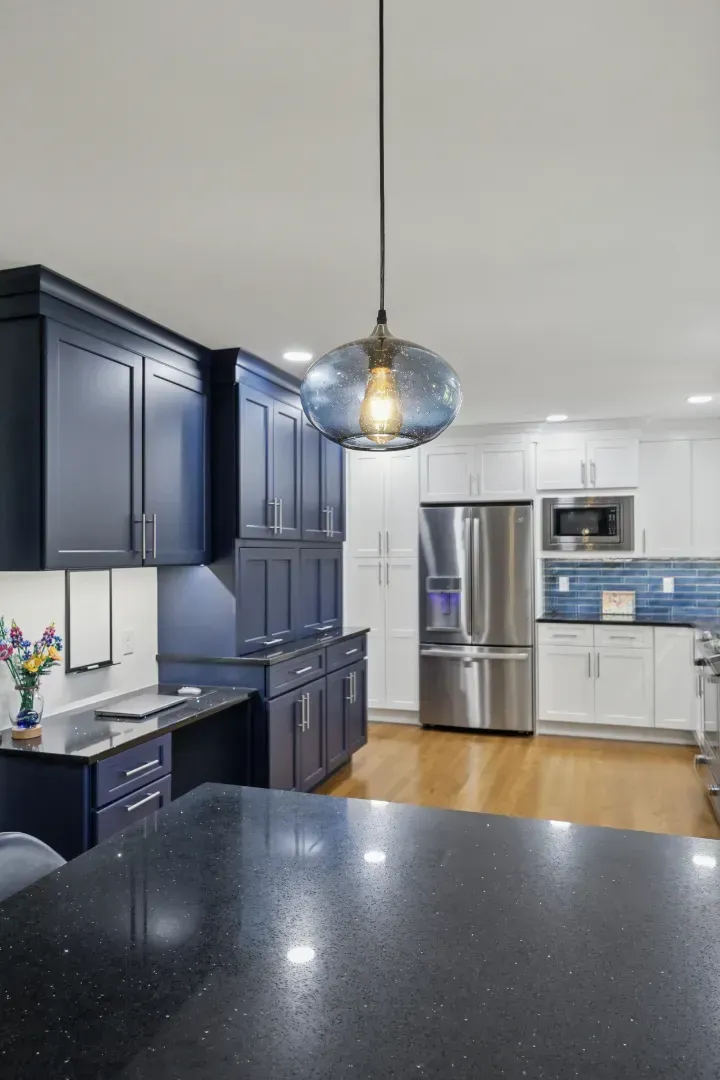 Hand writing in notebook with calculator and cash on a white table.