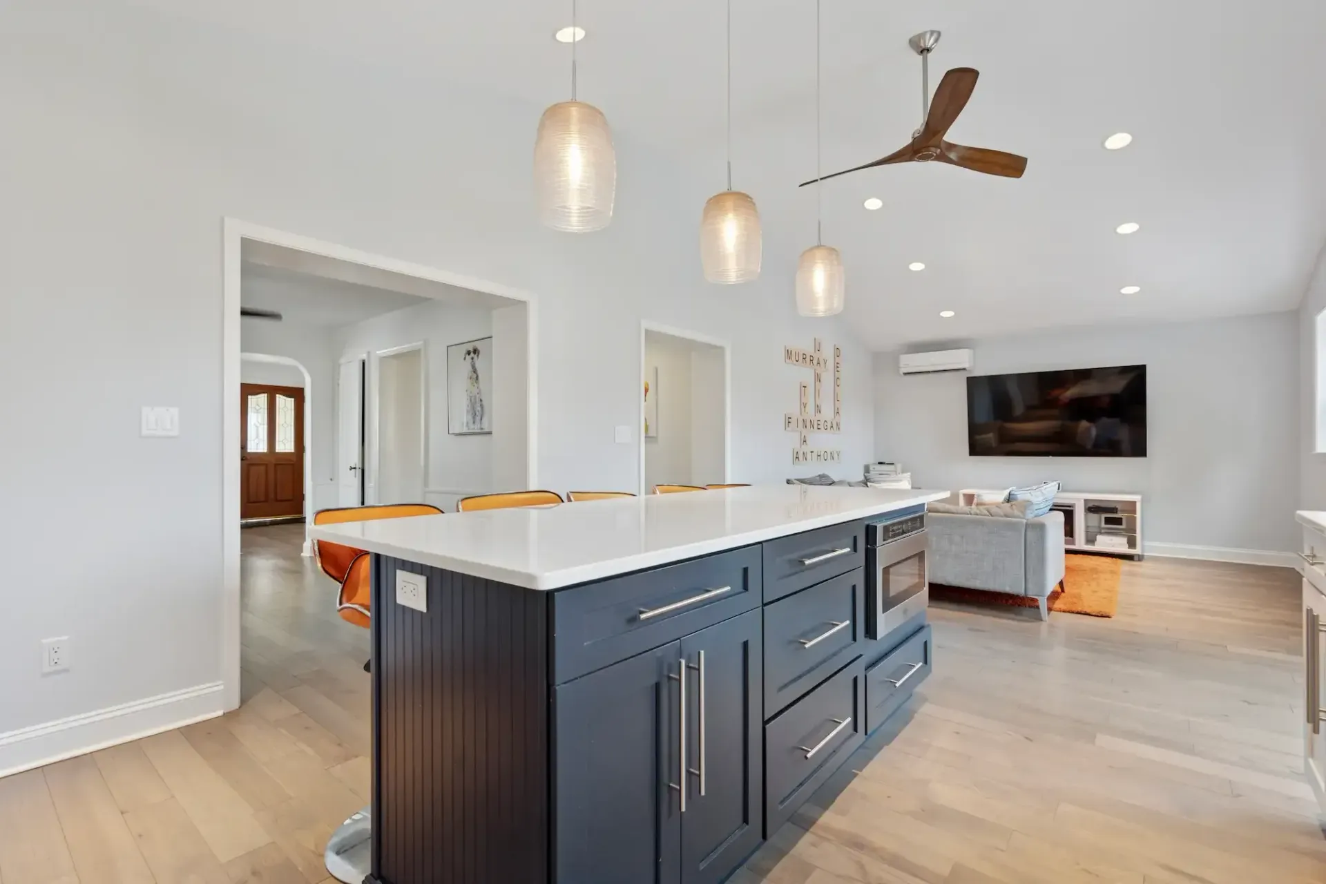 A kitchen with a large island and a ceiling fan.