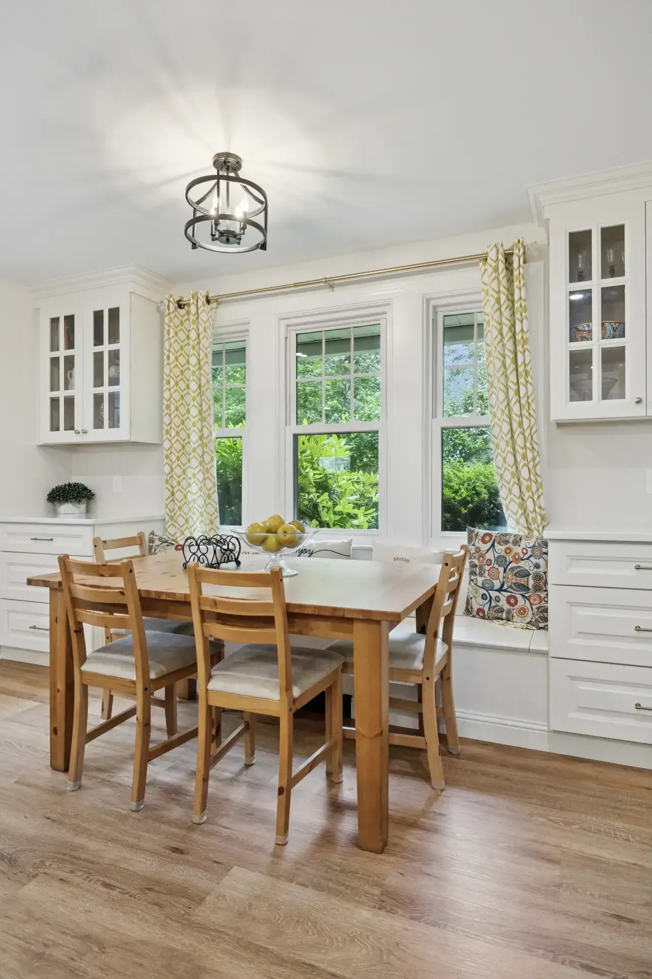 A dining room with a table and chairs and a window seat.