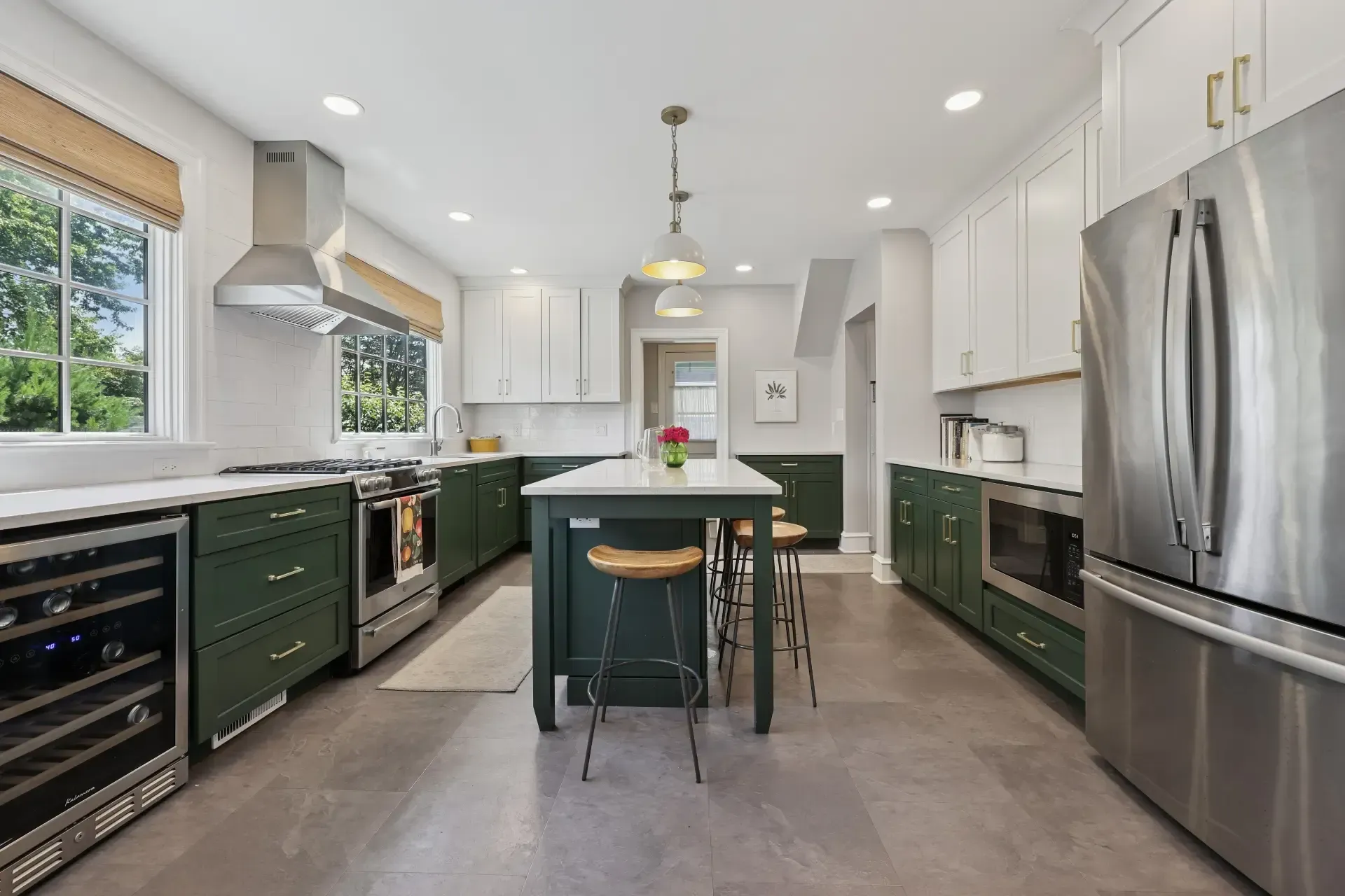 A kitchen with green cabinets and stainless steel appliances