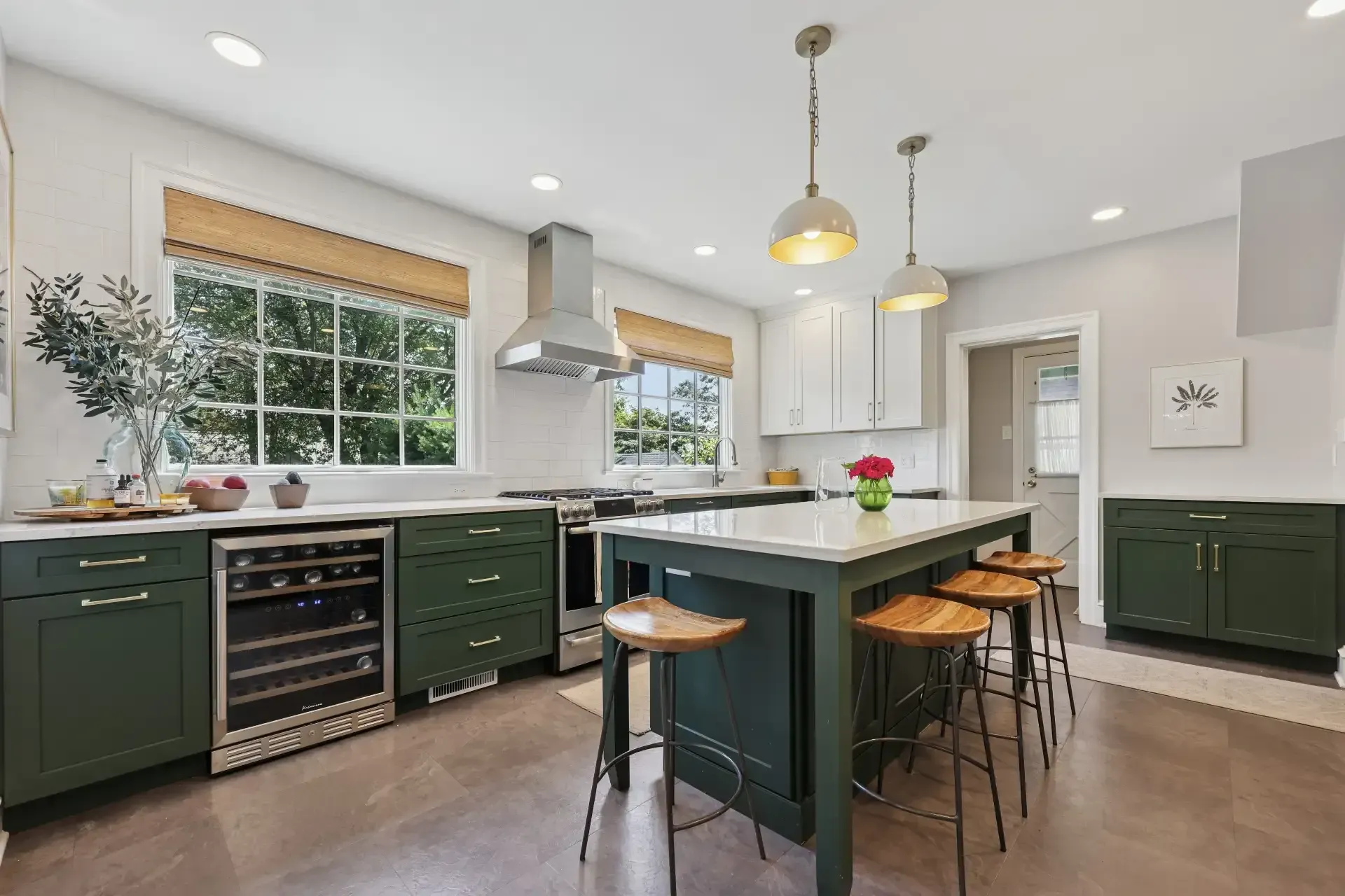 A kitchen with green cabinets and a large island.