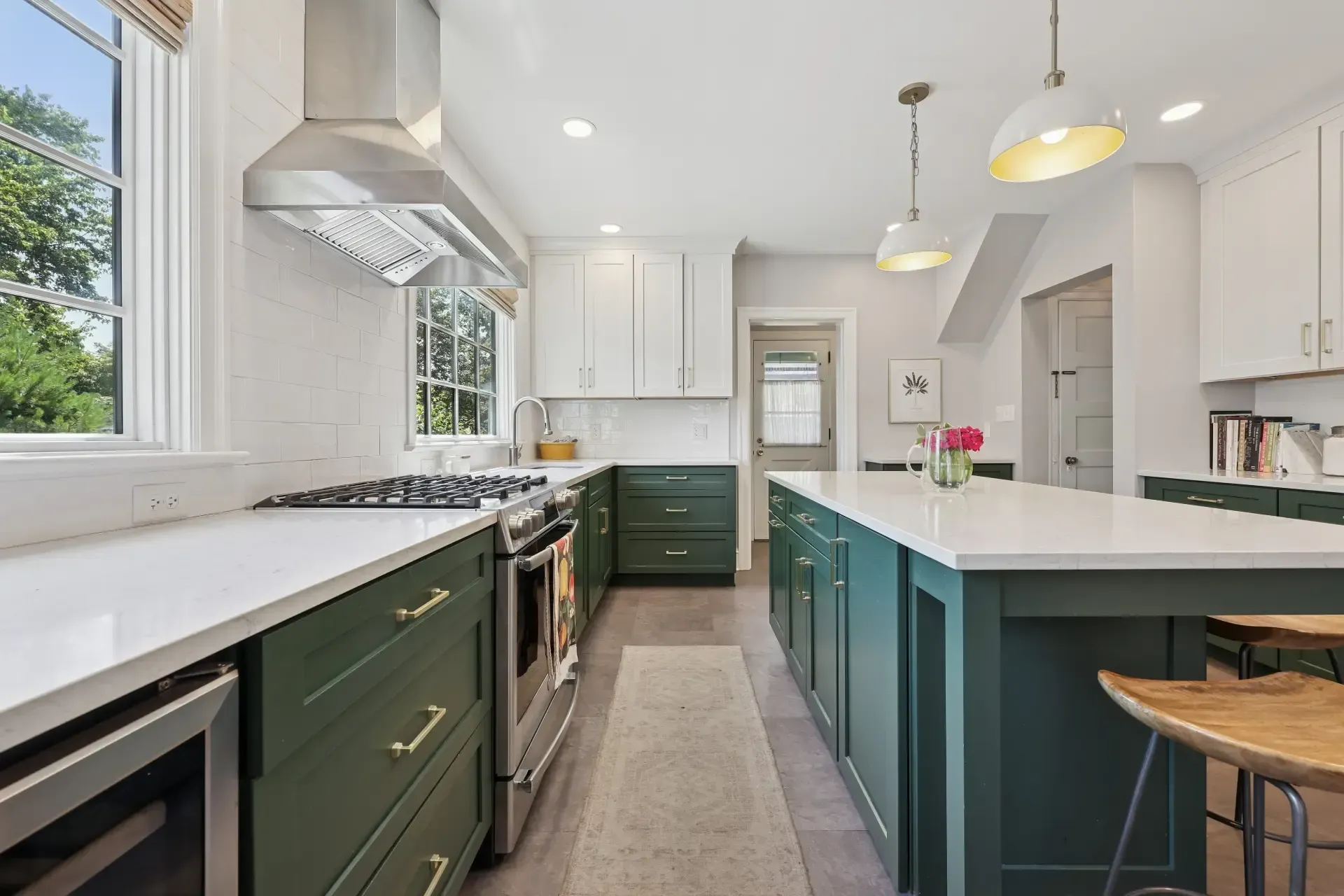 A kitchen with green cabinets and white counter tops
