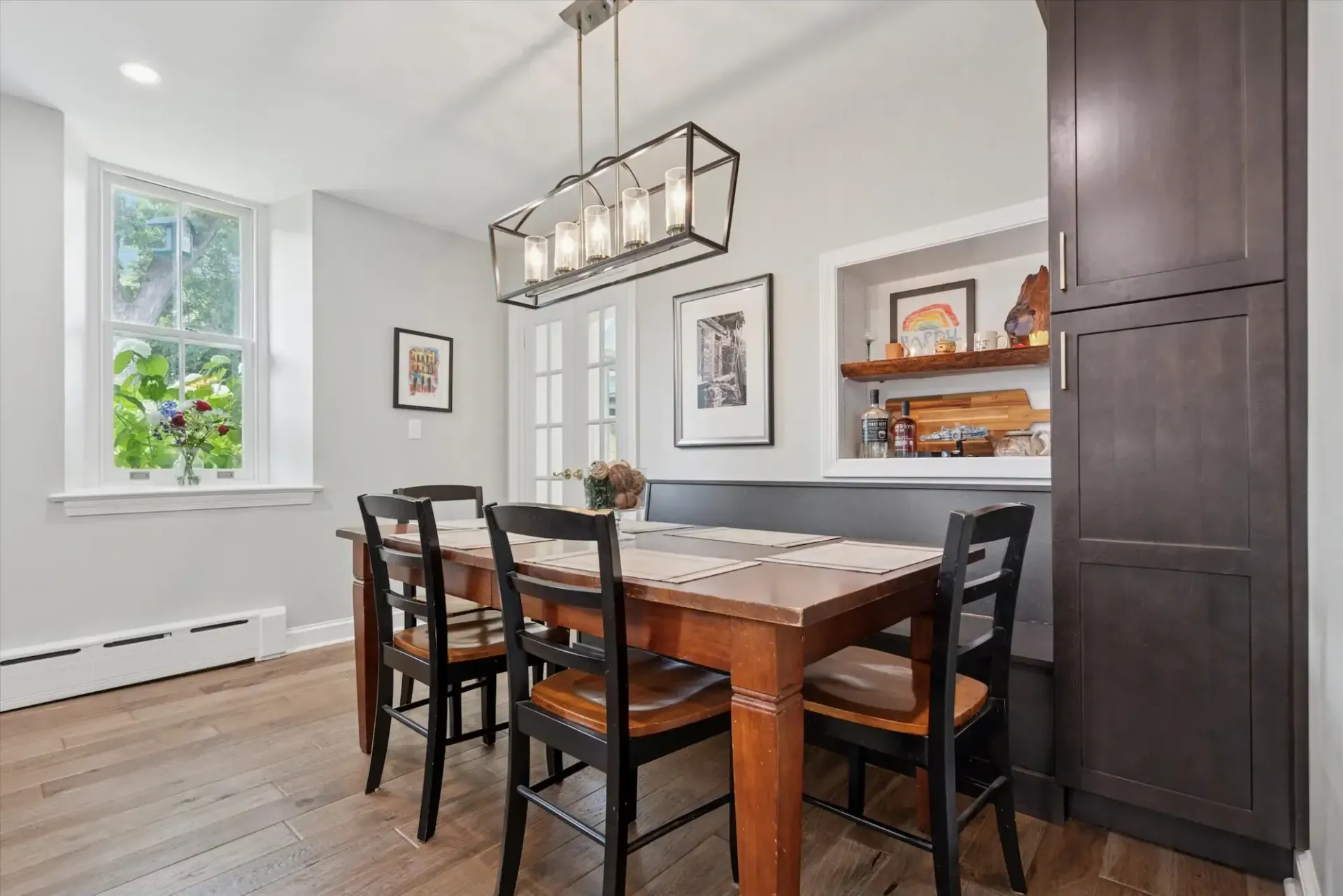 A dining room with a table and chairs and a window