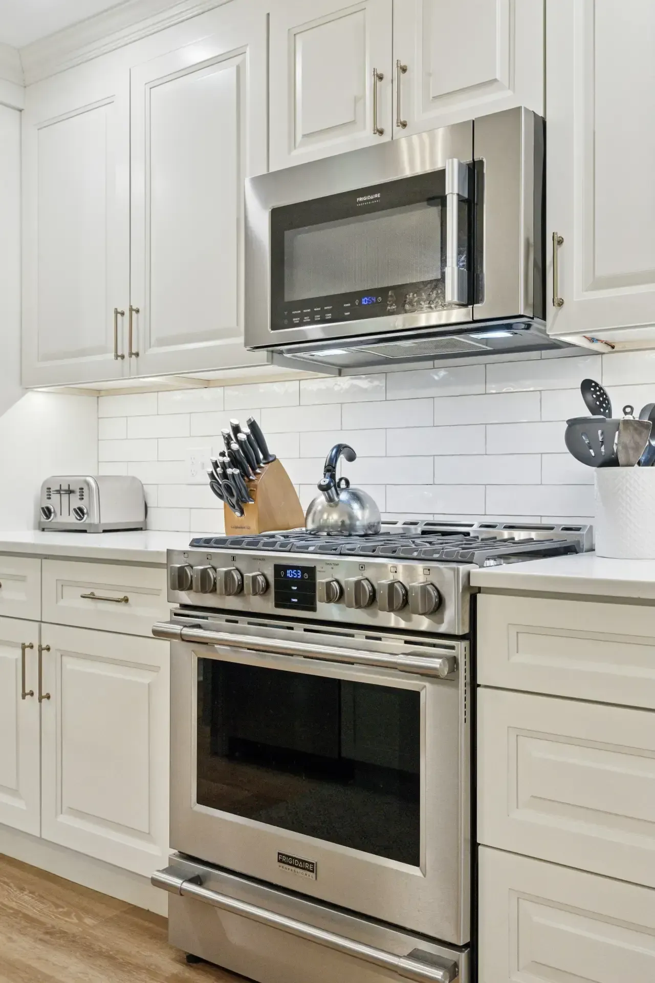 A kitchen with stainless steel appliances and white cabinets.