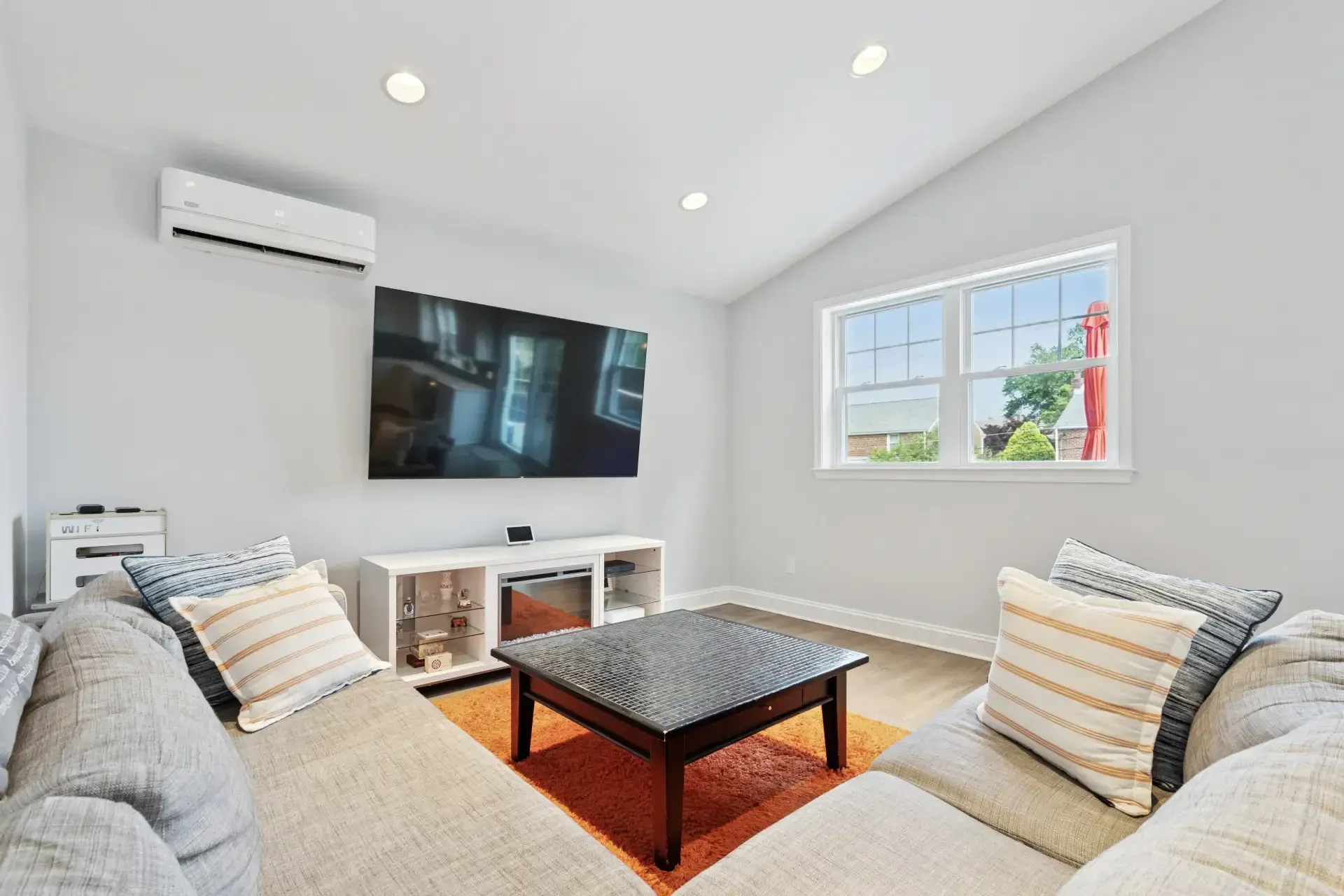 A living room with two couches , a coffee table and a flat screen tv.