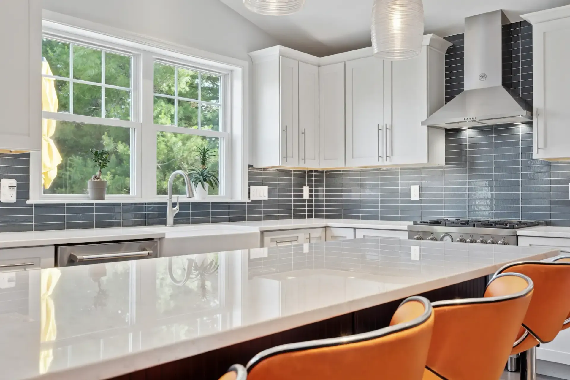 A kitchen with white cabinets , stainless steel appliances , and a large island.