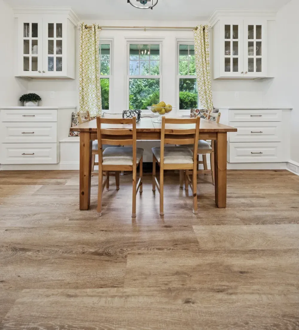 Hand writing in notebook with calculator and cash on a white table.