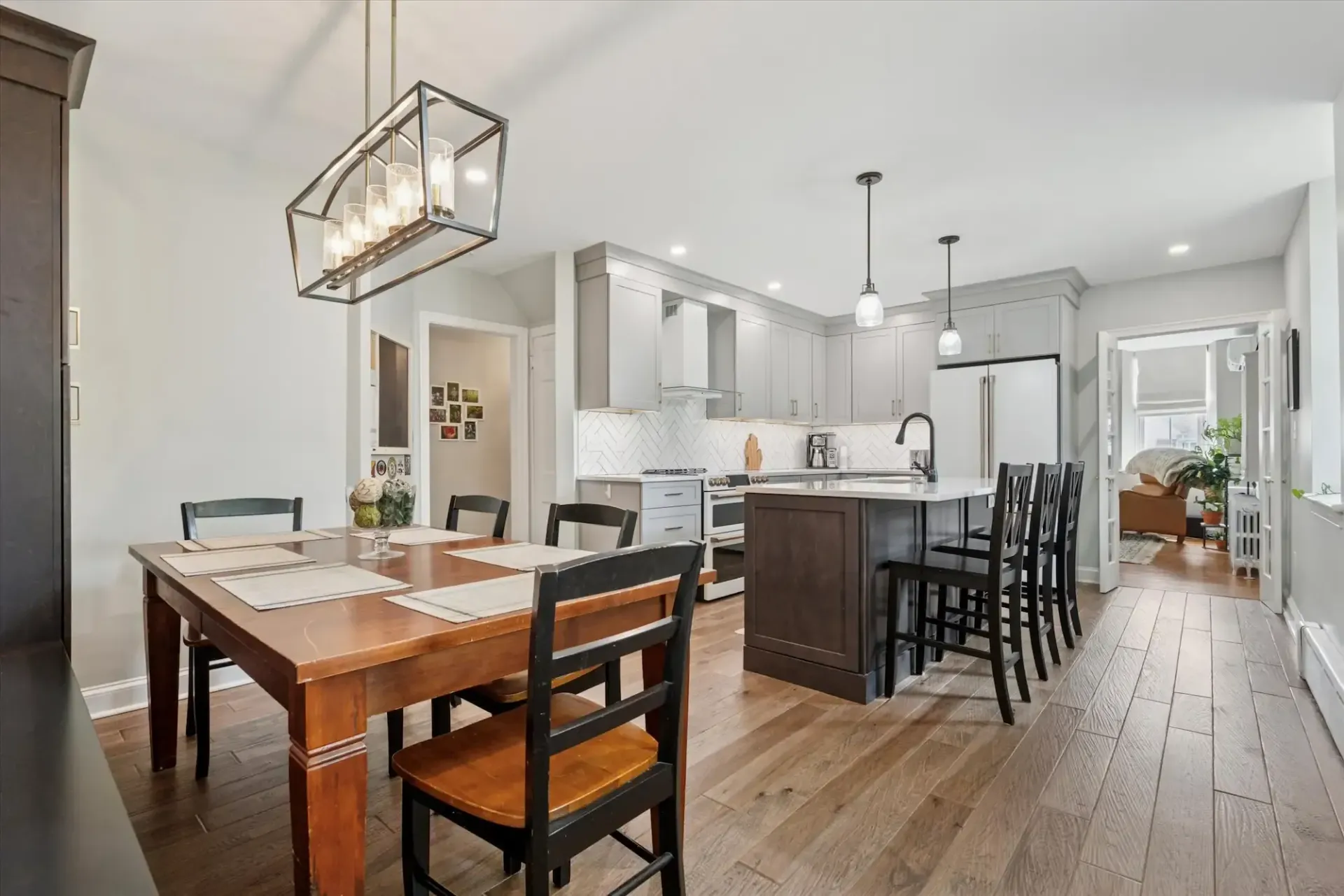 A dining room table and chairs in a kitchen with hardwood floors.