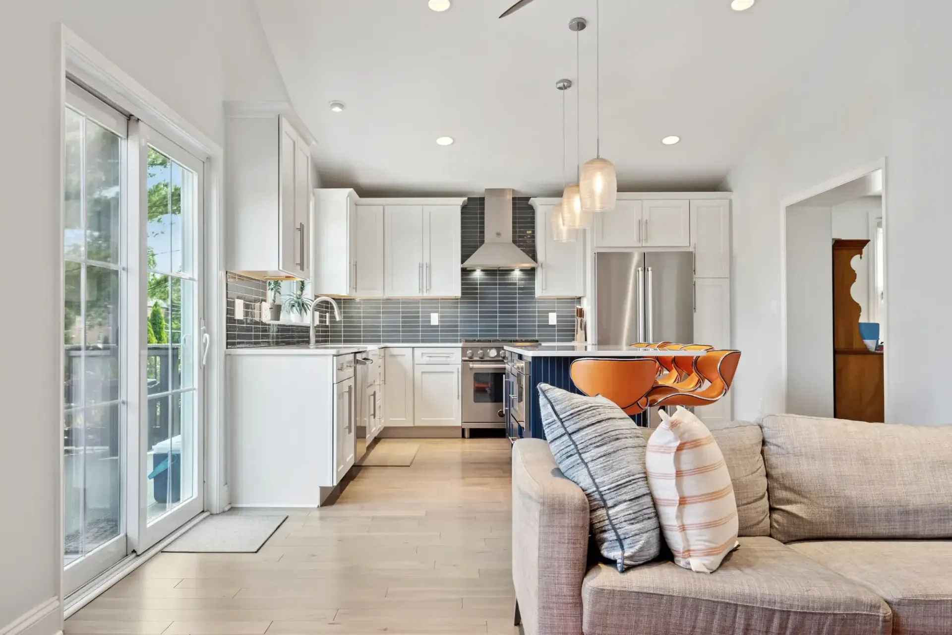 A living room with a couch and a kitchen in the background.