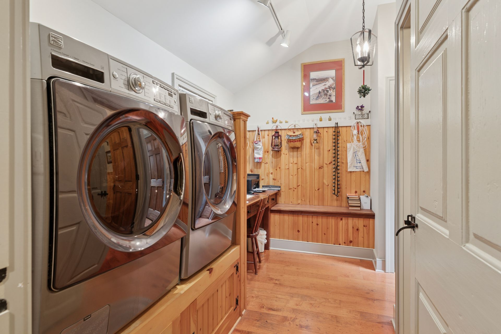 Screened-in porch with white paneling, stone pathway, small fountain, and surrounding greenery.