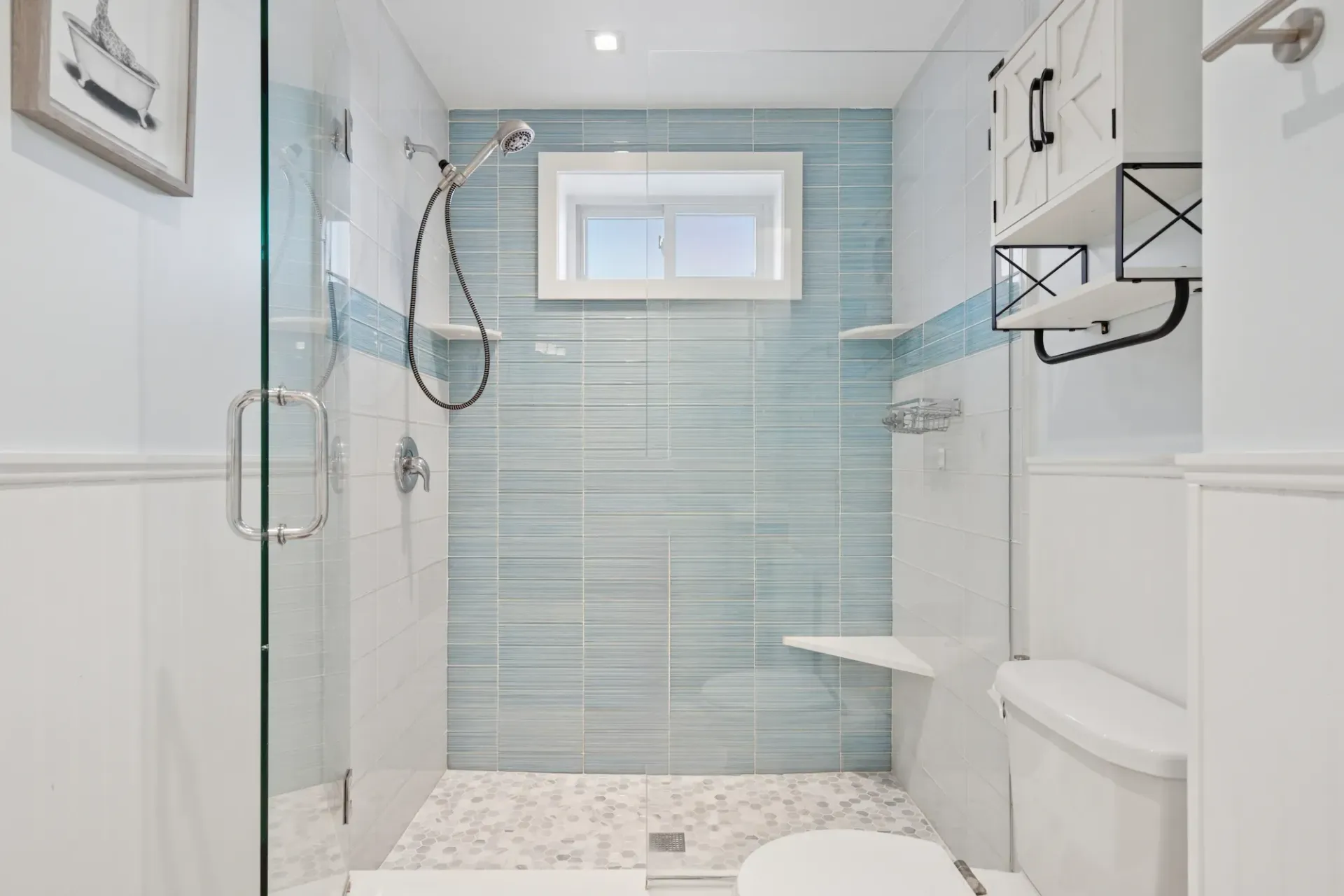 A bathroom with a toilet , shower , and window.