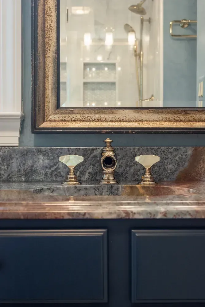 Hand writing in notebook with calculator and cash on a white table.