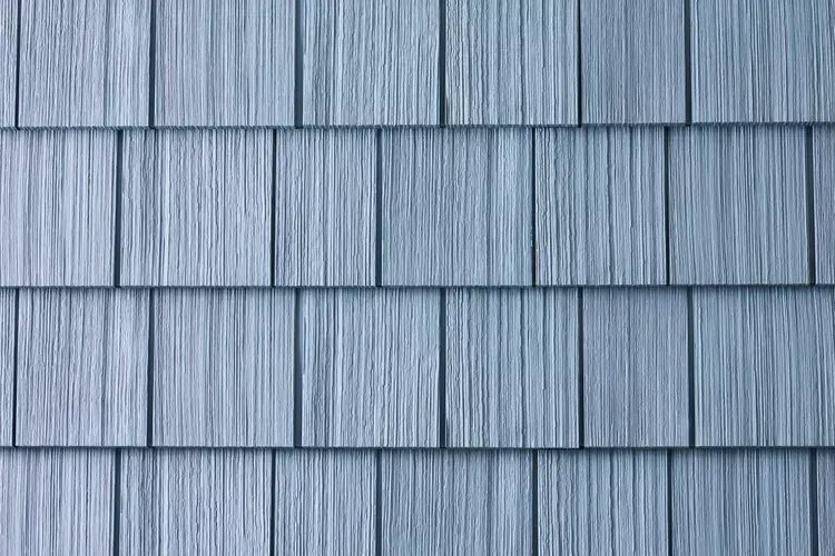 Hand writing in notebook with calculator and cash on a white table.