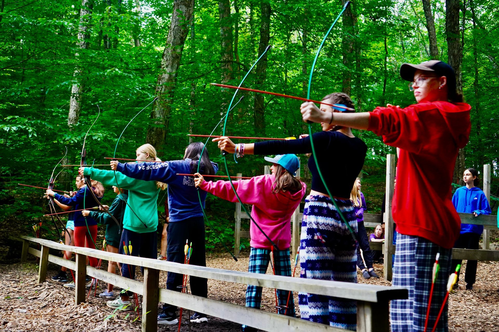 Children are playing the woods doing archery.