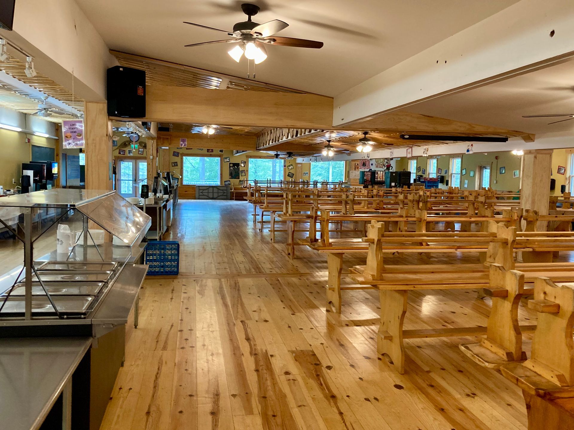A large dining room with wooden benches and a buffet.