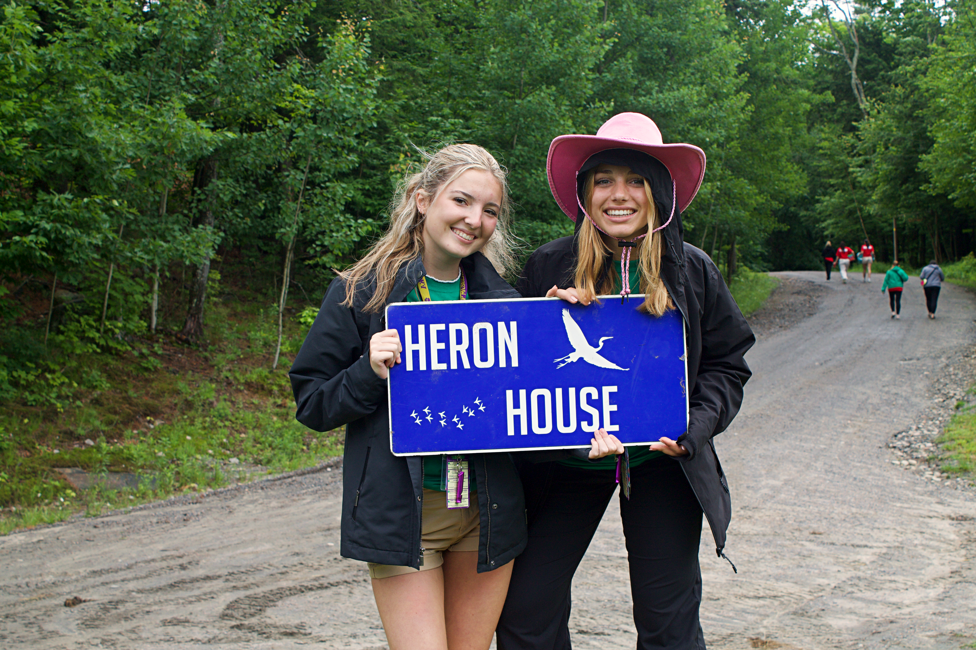Two girls holding a sign that says heron house