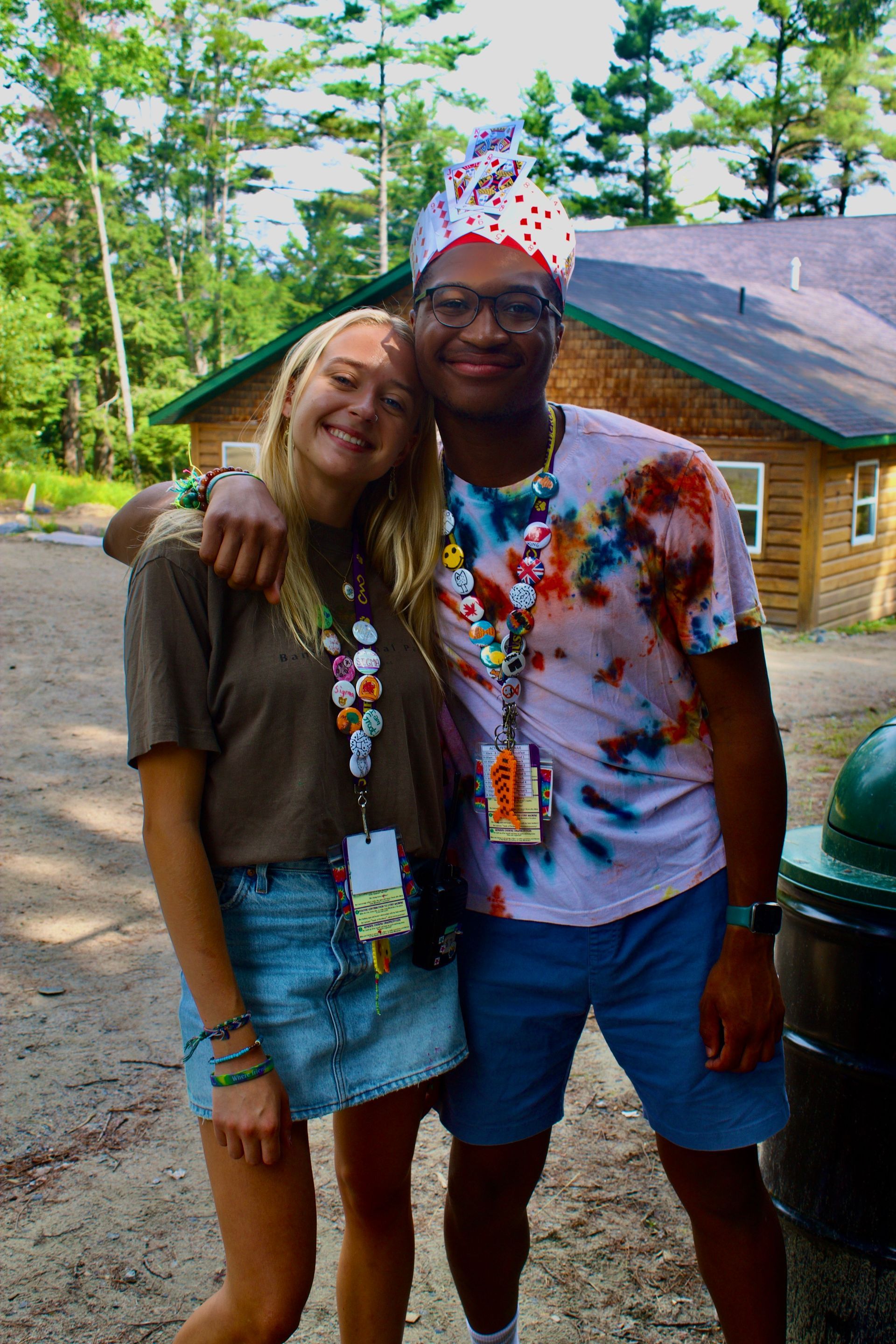 A man and a woman are posing for a picture in front of a cabin.