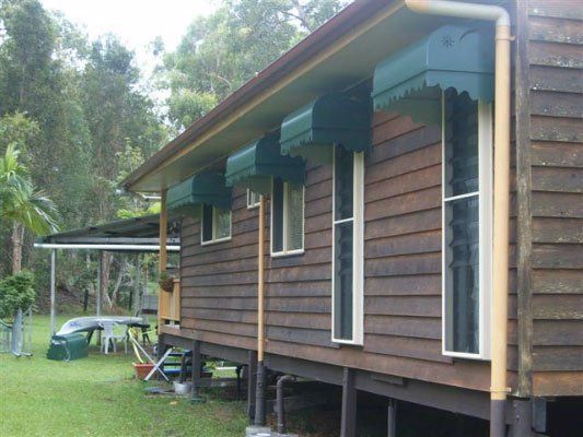 A Wooden House With Green Awnings On The Windows — Dalrymple Sheet Metal In Mount Isa, QLD