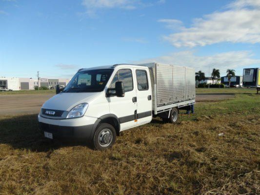 A White Van Is Parked In A Grassy Field — Dalrymple Sheet Metal In Townsville, QLD