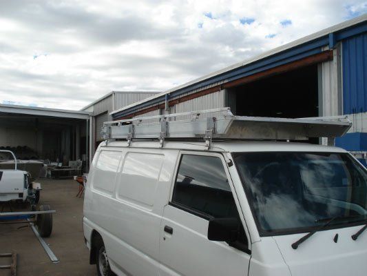 A White Van With A Ladder Rack On Top — Dalrymple Sheet Metal In Mount Isa, QLD