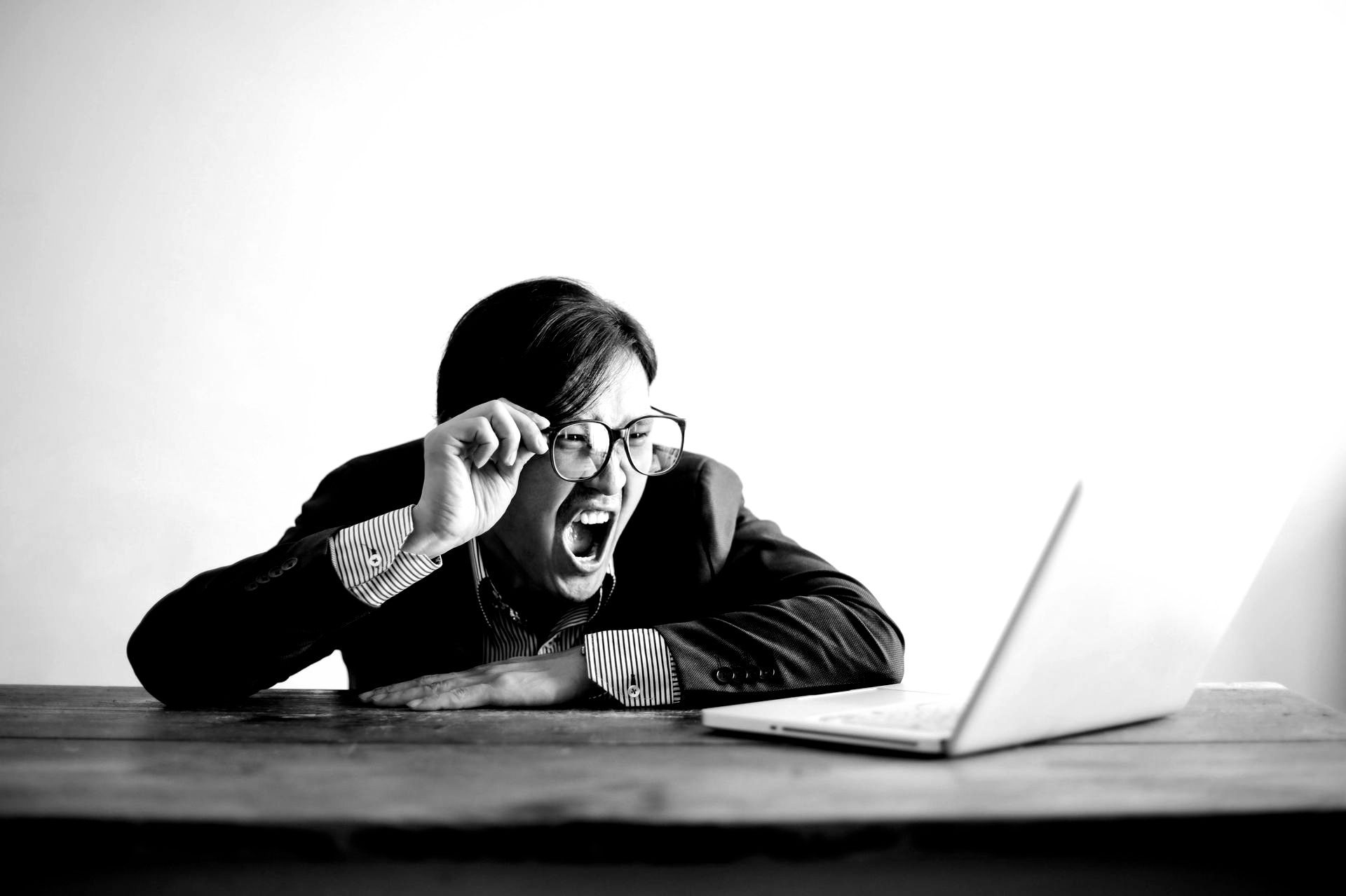 Gefrustreerde professional schreeuwt naar laptop tijdens werk