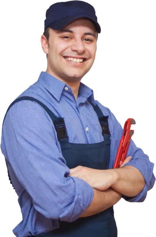 Smiling plumber in blue overalls and cap, holding red wrench with arms crossed.