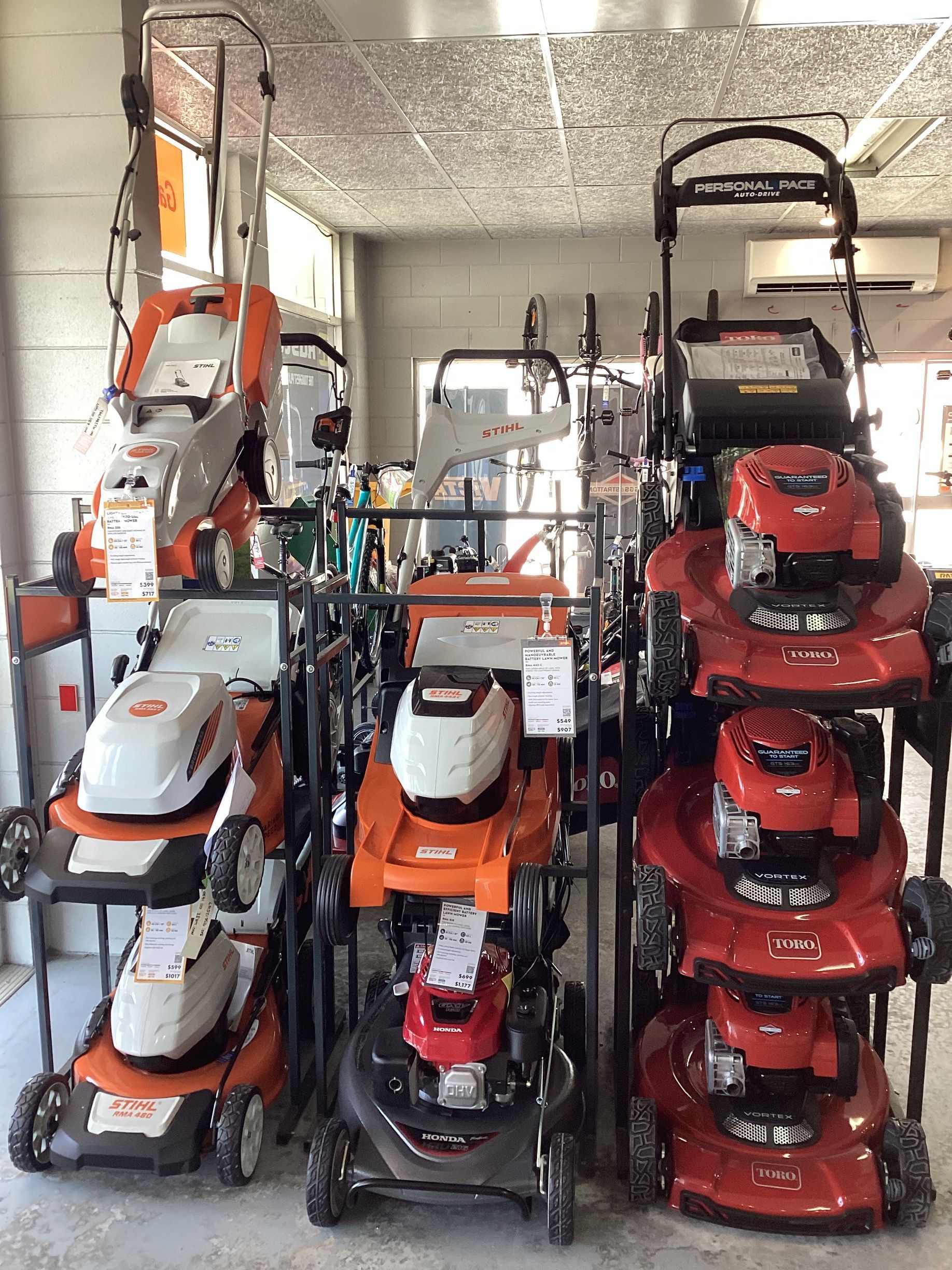 Red Lawnmower Cutting Grass — Lawn Mowers In Bowen QLD