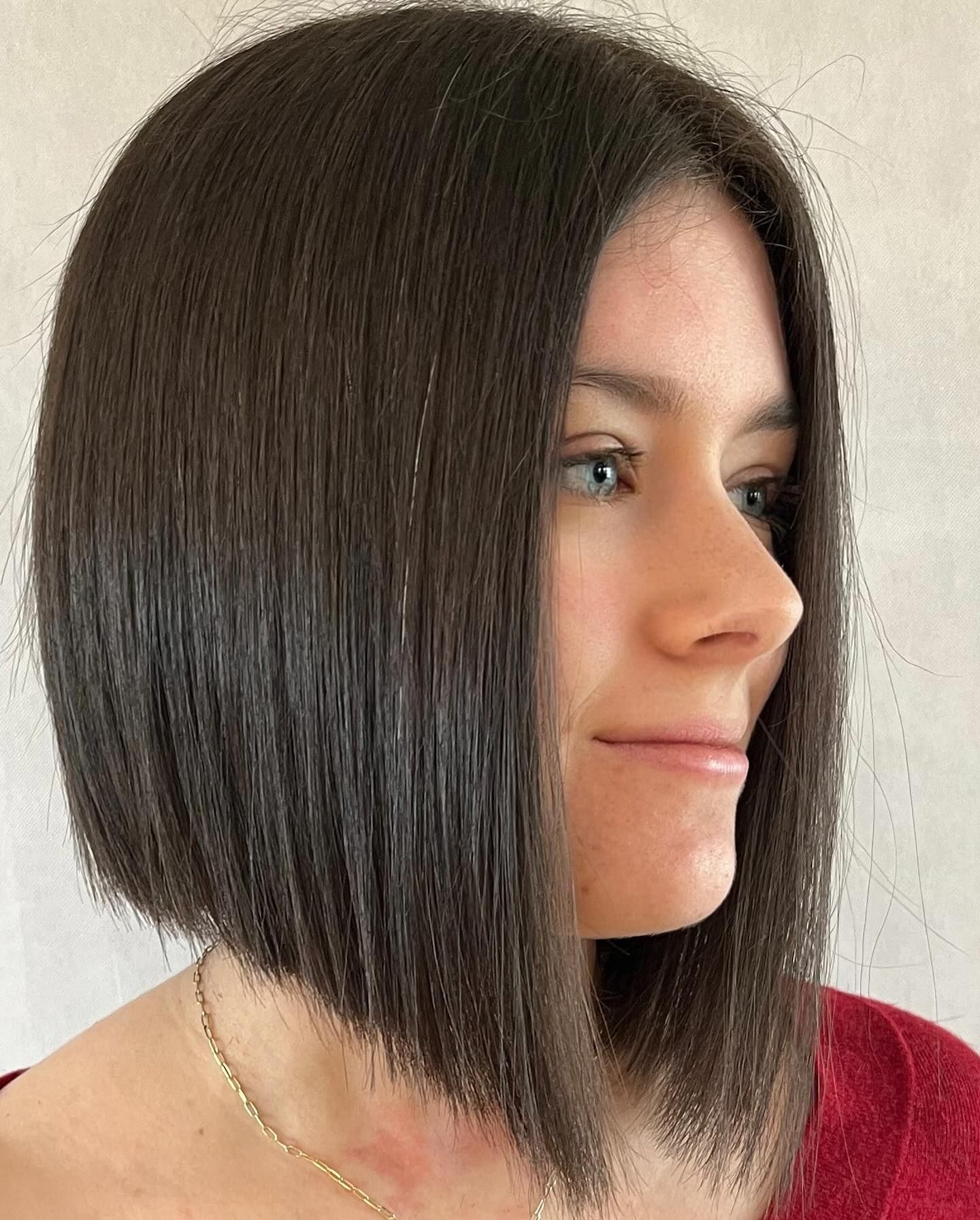 Una donna con un caschetto indossa una maglietta rossa.