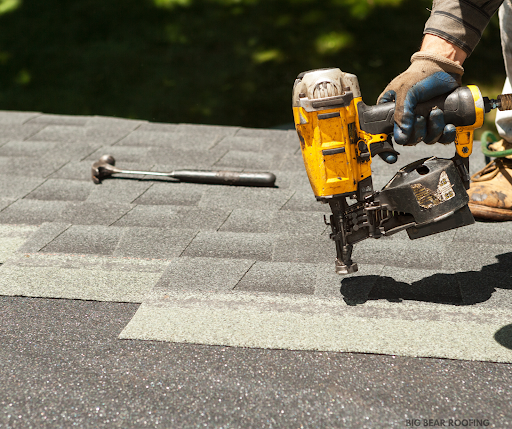 A roofer working on a shingle.